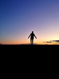 Silhouette man standing against clear sky during sunset