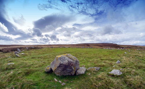 Scenic view of rocks on field against sky