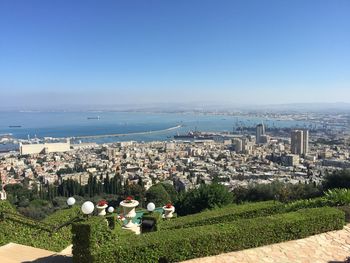 Panoramic view of sea and city against clear blue sky