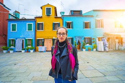 Portrait of young woman standing in city