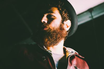 Low angle view of bearded man looking away in darkroom