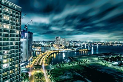 Illuminated buildings in city against sky at night