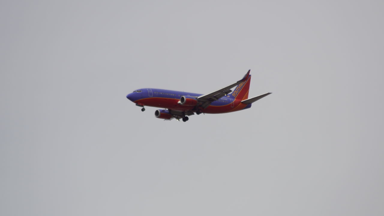 LOW ANGLE VIEW OF AIRPLANE FLYING IN CLEAR SKY