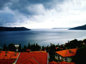 High angle view of houses by sea against sky