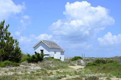 Lifeguard hut on field against sky