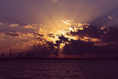 Scenic view of sea against dramatic sky during sunset