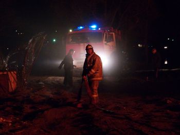Man standing on illuminated street at night