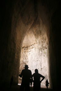 Silhouette people standing in cave