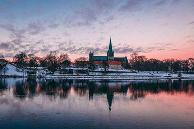 Reflection of building in lake at sunset