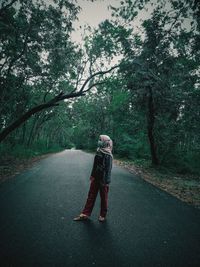 Rear view of woman walking on road