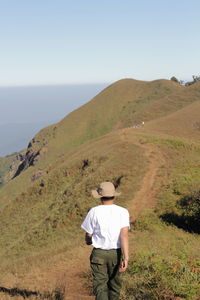 Rear view of man standing on mountain road