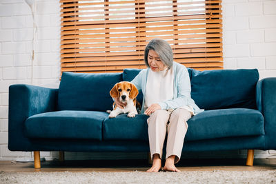 Portrait of young woman sitting on sofa at home