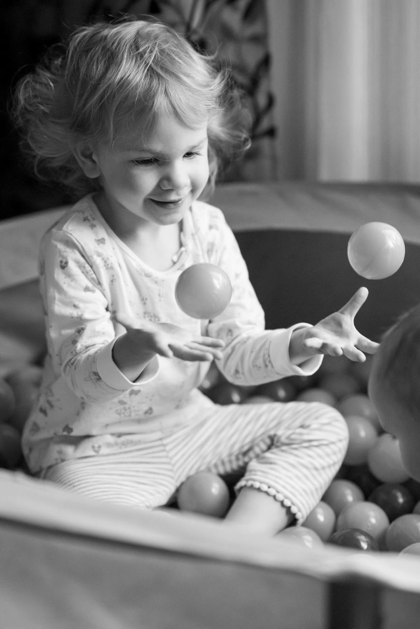 childhood, one person, real people, indoors, sitting, home interior, cute, lifestyles, playing, full length, girls, leisure activity, balloon, boys, food, blond hair, day, bubble wand