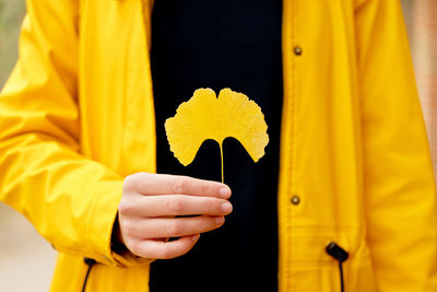 Midsection of man holding red flower