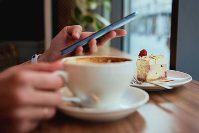 Woman have breakfast at cafe, use smartphone at cafe