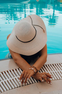 High angle view of woman sitting by swimming pool