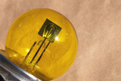 Close-up of yellow light bulb against wall