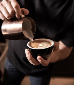 Cropped image of hand holding coffee cup