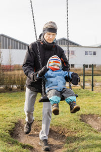 Full length of grandfather and baby girl at playground