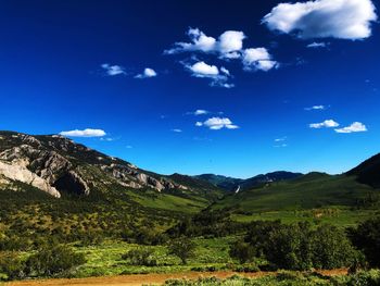 Scenic view of mountains against blue sky