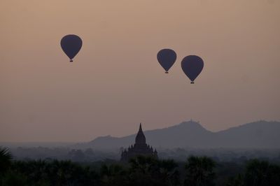 Silhouette of hot air balloons against sky during sunset