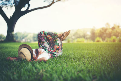 Woman relaxing on grassy field