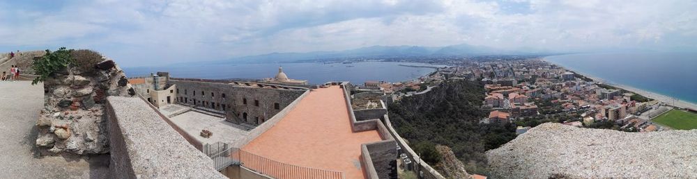 High angle view of townscape by sea against sky