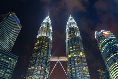 Low angle view of illuminated buildings against sky at night