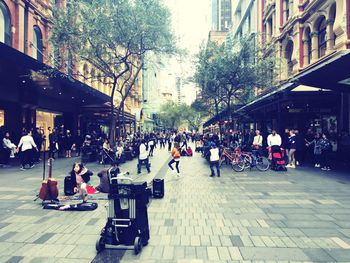 People sitting on sidewalk in city