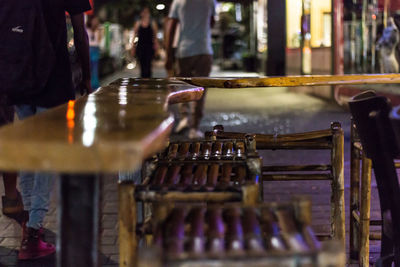 Wooden stools at table in sidewalk cafe during night