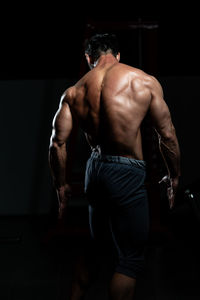 Shirtless man exercising in gym