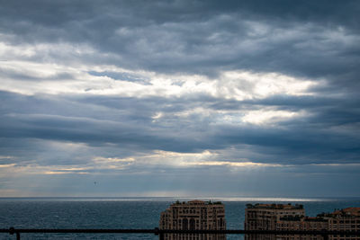 Scenic view of sea by buildings against sky