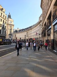 Group of people walking on street in city