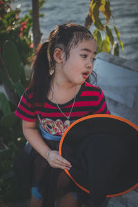 Girl holding witch hat looking away