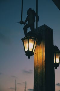 Low angle view of illuminated street light against sky at sunset