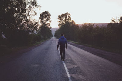Rear view of man on road against sky