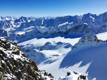 Scenic view of snowcapped mountains against blue sky