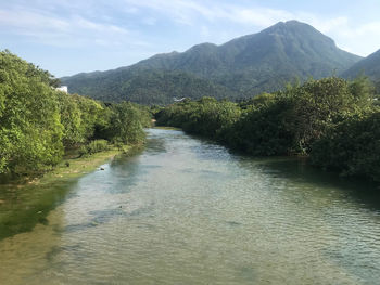 Scenic view of river amidst mountains against sky