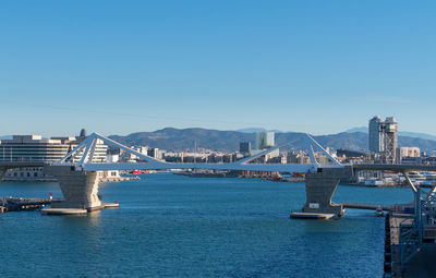 Bridge over bay against clear blue sky