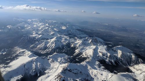 Aerial view of snowcapped mountains against sky