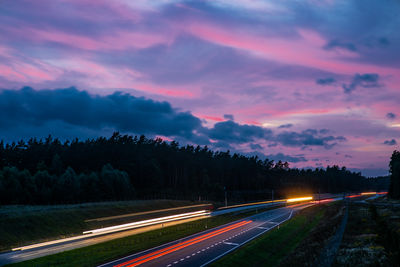 Light trails on road against sky during sunset