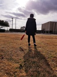 Rear view of man walking on field