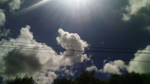 Low angle view of power lines against cloudy sky