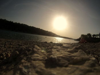 Scenic view of beach against clear sky at sunset