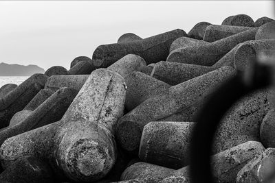 Close-up of old stack on land against sky