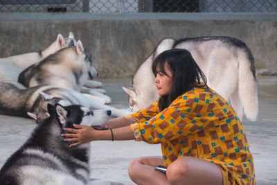 Mid adult woman with siberian husky sitting outdoors