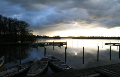 Pier on lake against cloudy sky