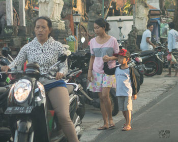 Portrait of people riding motorcycle on street