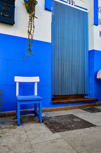 Empty chairs and tables against blue wall