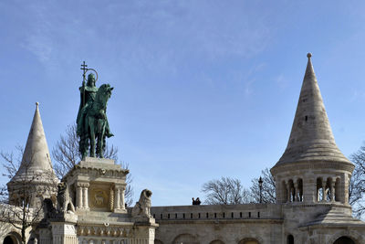 Low angle view of statues on building against sky